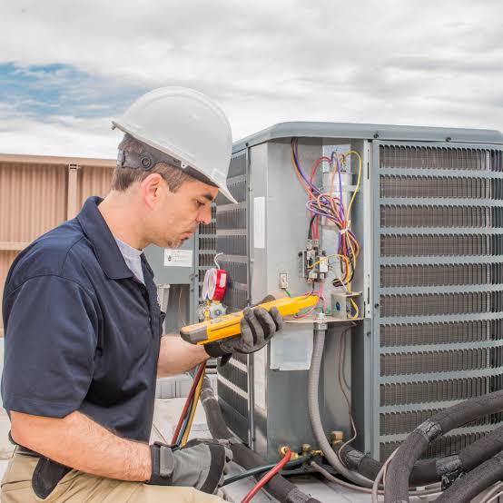 HVAC technician diagnosing electrical components in an outdoor air conditioner