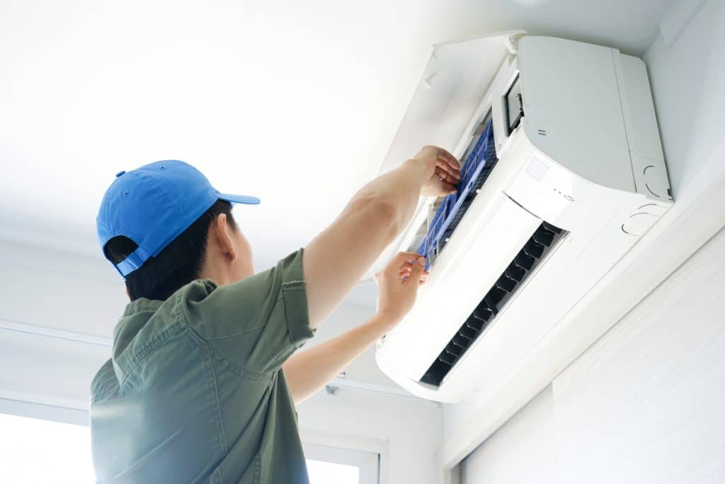 Technician maintaining a wall-mounted indoor climate system